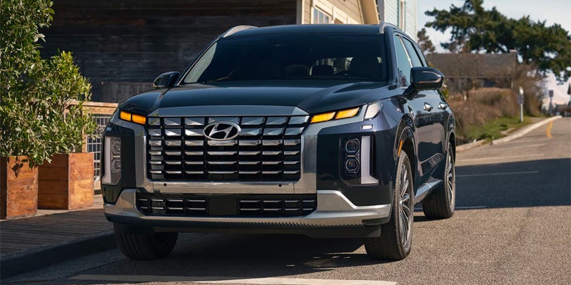 Dark blue Hyundai Palisade SUV parked on a residential street, highlighting its large cascading grille