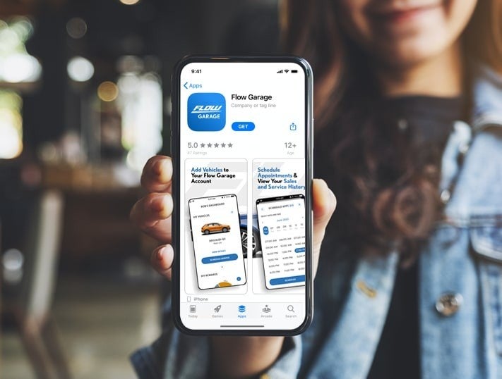 Person holds iPhone displaying Flow Garage app page in App Store, showing logo, ratings, and feature screenshots.